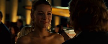 Movie still from “Green Lantern” (2011), directed by Martin Campbell – A beautiful woman with long earrings and a cocktail in her hand; Close Up shot, Over the shoulder angle