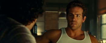 Movie still from “Green Lantern” (2011), directed by Martin Campbell – A person in a tank top looking at a mirror; Close Up shot, Over the shoulder angle