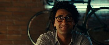 Movie still from “Green Lantern” (2011), directed by Martin Campbell – A person wearing glasses and smiling; Close Up shot, Over the shoulder angle