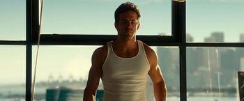 Movie still from “Green Lantern” (2011), directed by Martin Campbell – A person wearing a tank top near a window; Medium shot, Low angle