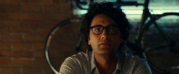 Movie still from “Green Lantern” (2011), directed by Martin Campbell – A person wearing glasses with a bicycle in the background; Close Up shot, Over the shoulder angle