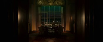 Movie still from “Green Lantern” (2011), directed by Martin Campbell – A table and chairs in front of an open window at night; Extreme Wide shot, Low angle