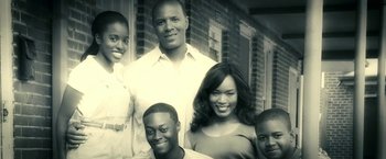 Movie still from “Green Lantern” (2011), directed by Martin Campbell – A group of people standing next to each other in front of a brick building; Medium shot, Low angle