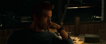 Movie still from “Green Lantern” (2011), directed by Martin Campbell – A man sitting at a table with his hand under his chin; Close Up shot, Over the shoulder angle