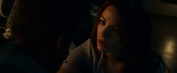 Movie still from “Green Lantern” (2011), directed by Martin Campbell – A beautiful young lady sitting in a dark room; Close Up shot, Over the shoulder angle