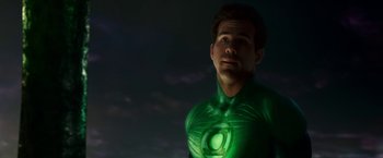Movie still from “Green Lantern” (2011), directed by Martin Campbell – A man dressed as a green lantern standing in the dark; Medium shot, Over the shoulder angle