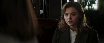 Movie still from “Greta” (2018), directed by Neil Jordan – A young woman sitting in front of a mirror in a room; Close Up shot, Over the shoulder angle