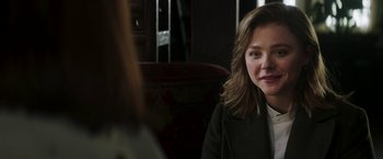 Movie still from “Greta” (2018), directed by Neil Jordan – A woman sitting in front of another woman in front of a mirror; Close Up shot, Over the shoulder angle