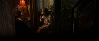 Movie still from “Greta” (2018), directed by Neil Jordan – A woman sitting in a chair talking on the phone; Medium shot, Over the shoulder angle