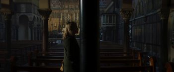 Movie still from “Greta” (2018), directed by Neil Jordan – A woman standing in front of an empty church pews; Wide shot, Low angle