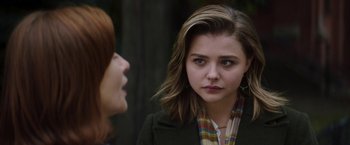 Movie still from “Greta” (2018), directed by Neil Jordan – Two women talking to each other in front of a forest; Close Up shot, Over the shoulder angle