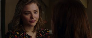 Movie still from “Greta” (2018), directed by Neil Jordan – A young woman looking at the camera while wearing a necklace; Close Up shot, Over the shoulder angle