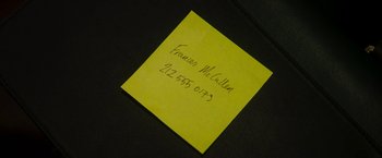 Movie still from “Greta” (2018), directed by Neil Jordan – A post - it note with a phone number on top of it; Extreme Close Up shot, Overhead angle