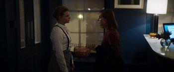 Movie still from “Greta” (2018), directed by Neil Jordan – Two women standing next to each other in front of a window; Medium shot, Over the shoulder angle