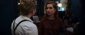 Movie still from “Greta” (2018), directed by Neil Jordan – A woman in a red and black dress talking to another woman; Close Up shot, Over the shoulder angle