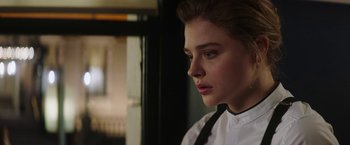 Movie still from “Greta” (2018), directed by Neil Jordan – A woman in a white shirt and black neck tie; Close Up shot, Over the shoulder angle
