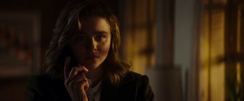 Movie still from “Greta” (2018), directed by Neil Jordan – A woman is talking on a cell phone in a dark room; Close Up shot, Low angle
