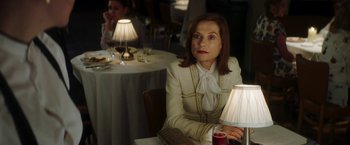 Movie still from “Greta” (2018), directed by Neil Jordan – A woman sitting in front of a table in a restaurant; Medium shot, Over the shoulder angle