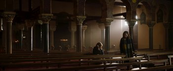 Movie still from “Greta” (2018), directed by Neil Jordan – A woman is sitting in a pew in a church; Extreme Wide shot, High angle
