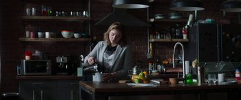 Movie still from “Greta” (2018), directed by Neil Jordan – A woman pouring a cup of coffee in a kitchen; Medium shot, Low angle