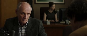 Movie still from “Greta” (2018), directed by Neil Jordan – An older man sitting in front of a computer; Close Up shot, Over the shoulder angle