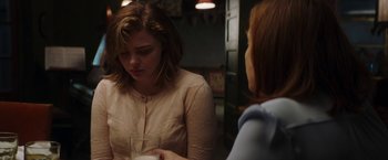 Movie still from “Greta” (2018), directed by Neil Jordan – Two women sitting at a table with a glass of wine; Medium shot, Over the shoulder angle