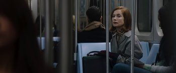 Movie still from “Greta” (2018), directed by Neil Jordan – A woman sitting on a train with a bag in her hand; Medium shot, Over the shoulder angle