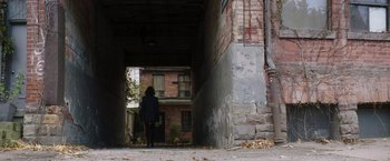 Movie still from “Greta” (2018), directed by Neil Jordan – A person is standing in a doorway of an old building; Extreme Wide shot, High angle