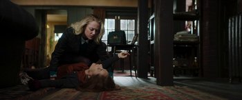 Movie still from “Greta” (2018), directed by Neil Jordan – A woman sitting on the ground next to another woman; Medium shot, High angle
