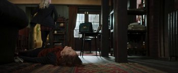Movie still from “Greta” (2018), directed by Neil Jordan – A person laying on the ground in a living room; Wide shot, High angle