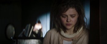 Movie still from “Greta” (2018), directed by Neil Jordan – A young woman is sad while looking at the camera; Close Up shot, High angle