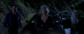 Movie still from “I Know What You Did Last Summer” (1997), directed by Jim Gillespie – A woman wearing a tiara standing next to a car; Medium shot, Low angle