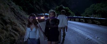 Movie still from “I Know What You Did Last Summer” (1997), directed by Jim Gillespie – A group of people walking down a street at night; Medium shot, Over the shoulder angle