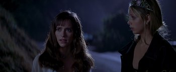 Movie still from “I Know What You Did Last Summer” (1997), directed by Jim Gillespie – A woman standing in front of a road at night; Close Up shot, Over the shoulder angle