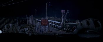 Movie still from “I Know What You Did Last Summer” (1997), directed by Jim Gillespie – A wooden pier with a sign on it's side; Extreme Wide shot, High angle