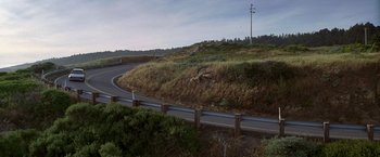 Movie still from “I Know What You Did Last Summer” (1997), directed by Jim Gillespie – A road with a fence on the side of the road; Extreme Wide shot, High angle