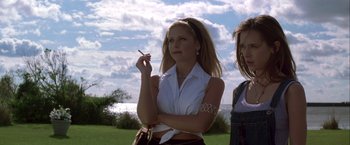 Movie still from “I Know What You Did Last Summer” (1997), directed by Jim Gillespie – A woman holding a cigarette standing next to another woman in a field; Medium shot, Low angle