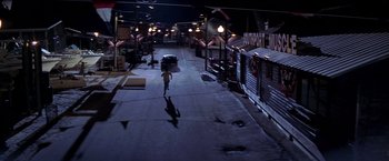 Movie still from “I Know What You Did Last Summer” (1997), directed by Jim Gillespie – A person walking down a street at night with an umbrella; Extreme Wide shot, High angle