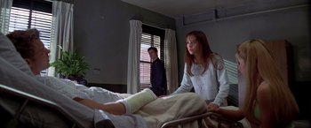 Movie still from “I Know What You Did Last Summer” (1997), directed by Jim Gillespie – A woman standing next to a man in a hospital bed; Medium shot, Over the shoulder angle