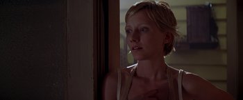 Movie still from “I Know What You Did Last Summer” (1997), directed by Jim Gillespie – A woman standing next to a door looking out a window; Close Up shot, Low angle
