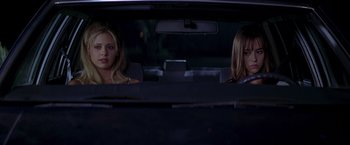 Movie still from “I Know What You Did Last Summer” (1997), directed by Jim Gillespie – Two women sitting in the back seat of a car at night; Medium shot, Low angle