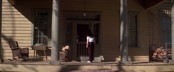 Movie still from “I Know What You Did Last Summer” (1997), directed by Jim Gillespie – A woman standing on the steps of an old house; Wide shot, Low angle