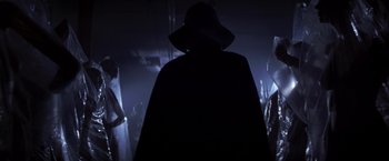 Movie still from “I Know What You Did Last Summer” (1997), directed by Jim Gillespie – A man in a black hat and a black cape; Medium shot, Low angle