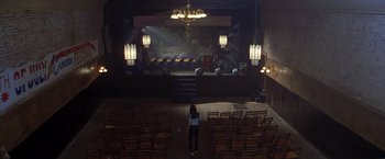 Movie still from “I Know What You Did Last Summer” (1997), directed by Jim Gillespie – A woman standing in front of an empty stage; Extreme Wide shot, High angle
