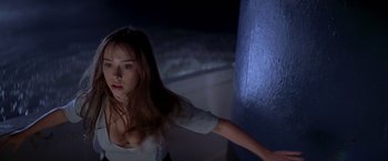 Movie still from “I Know What You Did Last Summer” (1997), directed by Jim Gillespie – A woman in a white shirt is standing in a dark room; Medium shot, Low angle