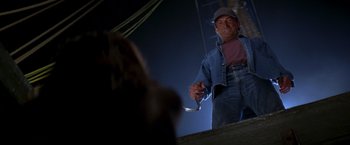 Movie still from “I Know What You Did Last Summer” (1997), directed by Jim Gillespie – A man holding a knife in his hand while standing next to a woman; Medium shot, Low angle