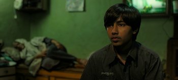 Movie still from “Gully Boy” (2019), directed by Zoya Akhtar – A man in a black shirt is sitting in a room; Close Up shot, High angle