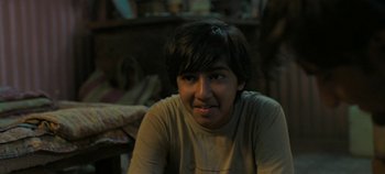 Movie still from “Gully Boy” (2019), directed by Zoya Akhtar – A young man sitting in a room with a book; Close Up shot, Over the shoulder angle