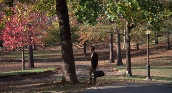 Movie still from “Hair” (1979), directed by Milos Forman – A man walking in a park holding a suitcase; Extreme Wide shot, High angle