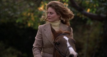 Movie still from “Hair” (1979), directed by Milos Forman – A woman in a brown jacket is riding a brown horse; Close Up shot, Low angle